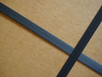 Two black textured straps crossing over a brown cardboard surface.