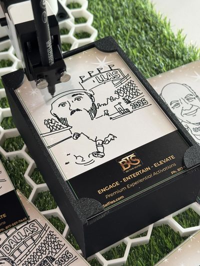 A pen drawing a sports-themed caricature on a card in a black holder.