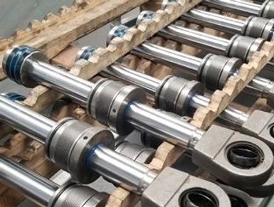 A set of hydraulic cylinders neatly arranged on a pallet.