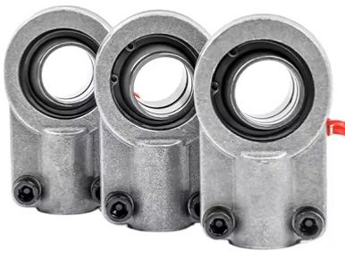 Three metallic mechanical components with circular openings and black rubber seals.