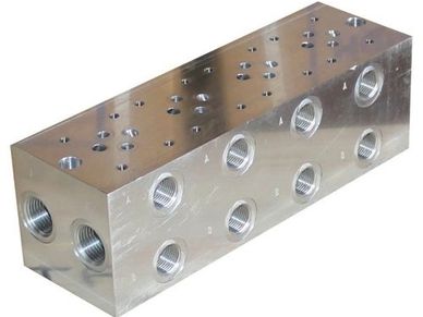 Metal hydraulic manifold block with multiple threaded ports.