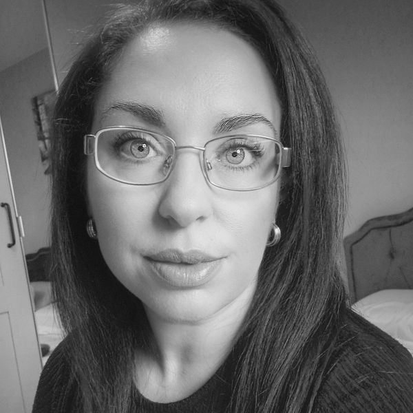 Black and white close-up portrait of a woman with glasses.