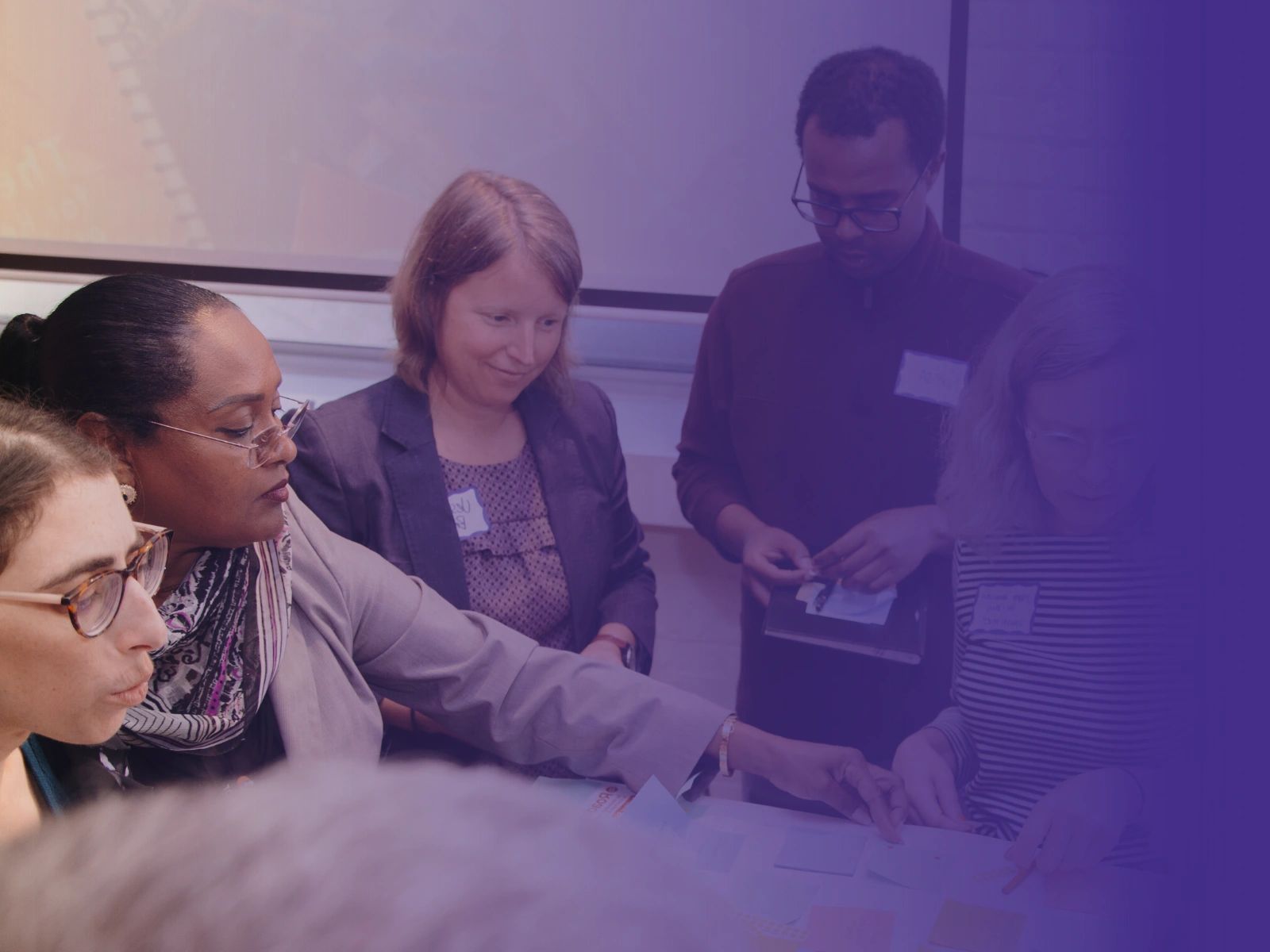 Diverse group collaborating on a project around a table.