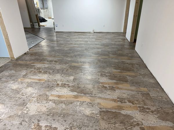 Newly installed stone-patterned flooring in an empty room under construction.