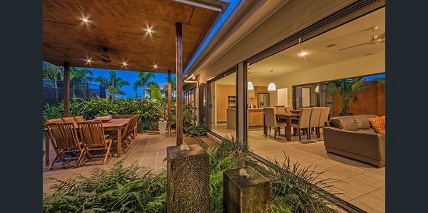 Cozy outdoor and indoor dining area with lush greenery.
