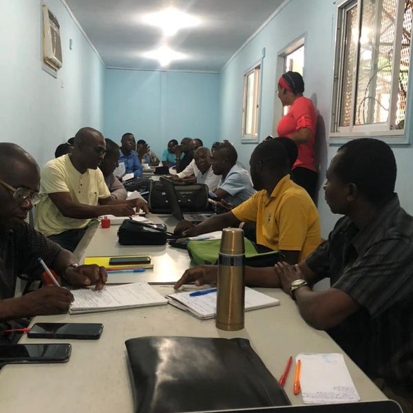People engaged in a meeting or study session in a narrow room.