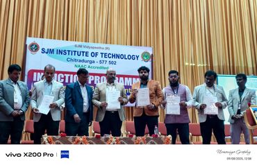 Group of men holding certificates on stage at SJM Institute of Technology induction program.