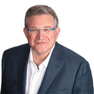 Man in glasses and suit smiling.