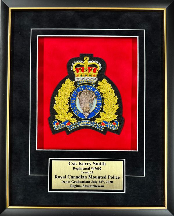 Framed Royal Canadian Mounted Police badge and nameplate for Cst. Kerry Smith.