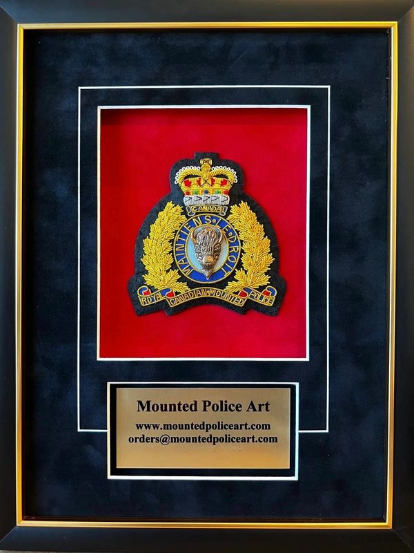 Framed Royal Canadian Mounted Police emblem with contact information plaque.