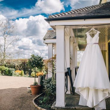 photo of a white wedding dress hanging outside a house