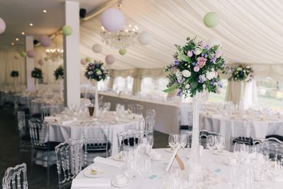 photo of a wedding venue with tables decorated in lilac and sage green theme