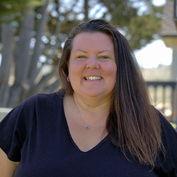 Smiling woman outdoors with long hair.