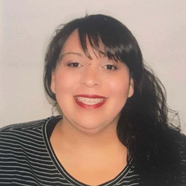 Smiling woman with dark hair and red lipstick.