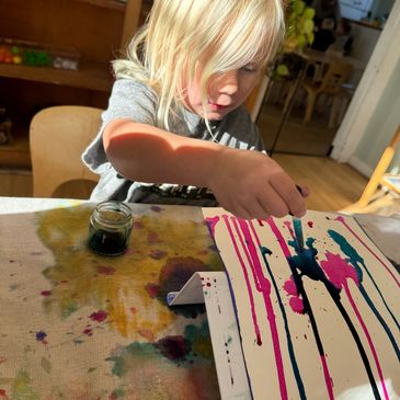 Child painting with vibrant colors on canvas.