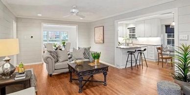 Cozy living room with wooden floors and an open kitchen layout.