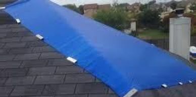 Blue tarp covering a damaged roof section for protection.