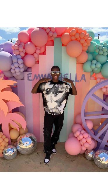 A guy posing in the photo booth backdrop 