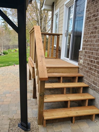 Wooden porch steps leading to a French door.