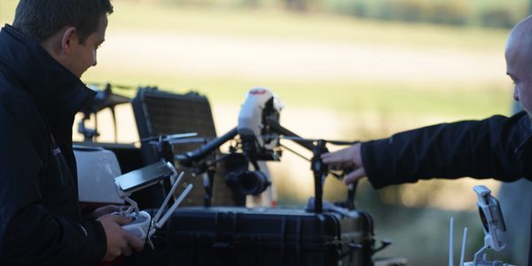 Two men operating a professional drone outdoors.