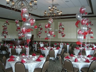 Elegant banquet hall decorated with red and silver balloons for a celebration.