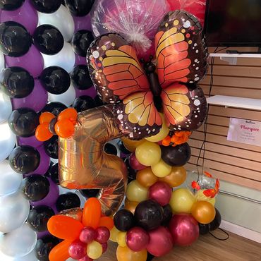 Colorful butterfly and number 5 balloons at a festive event.