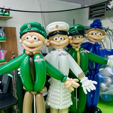 Four balloon figures dressed as military personnel in various uniforms.