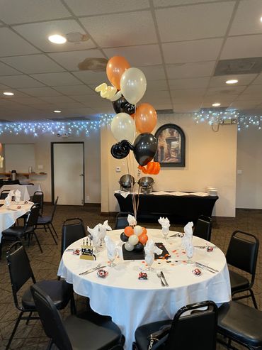 Table set for a Halloween party with themed balloons and decorations.