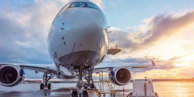 Front view of a large airplane on the runway during sunset.