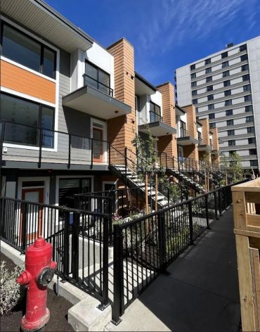 Modern townhouse complex with balconies and stairs.