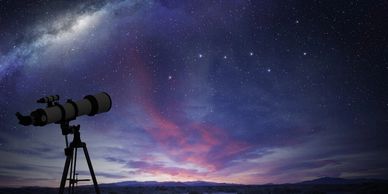 Telescope pointed at a starry night sky with the Milky Way visible.