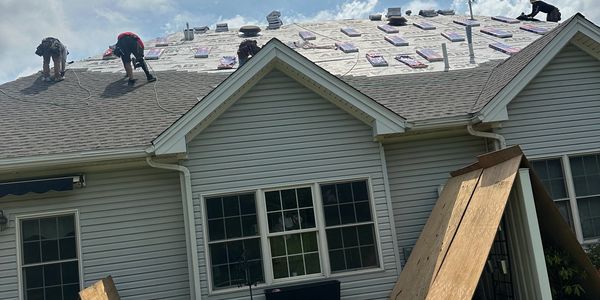 Roofing contractors discussing an installation project with homeowners.