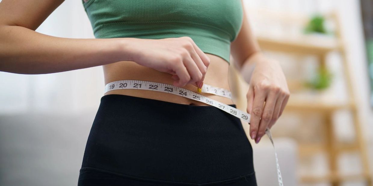 Woman measuring her waist