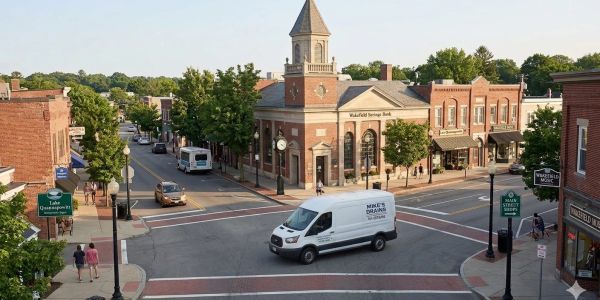Quiet small town intersection with a white delivery van.