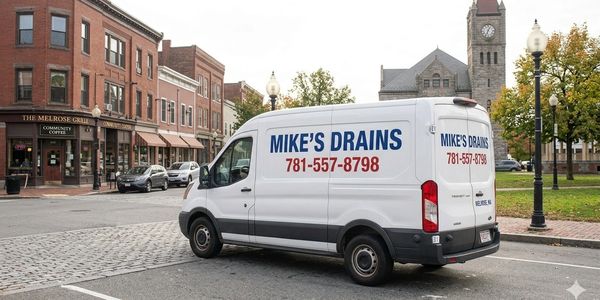 Mike's Drains service van parked in a city area.
