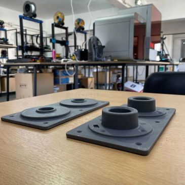 Piezas impresas en 3D sobre una mesa en un taller.