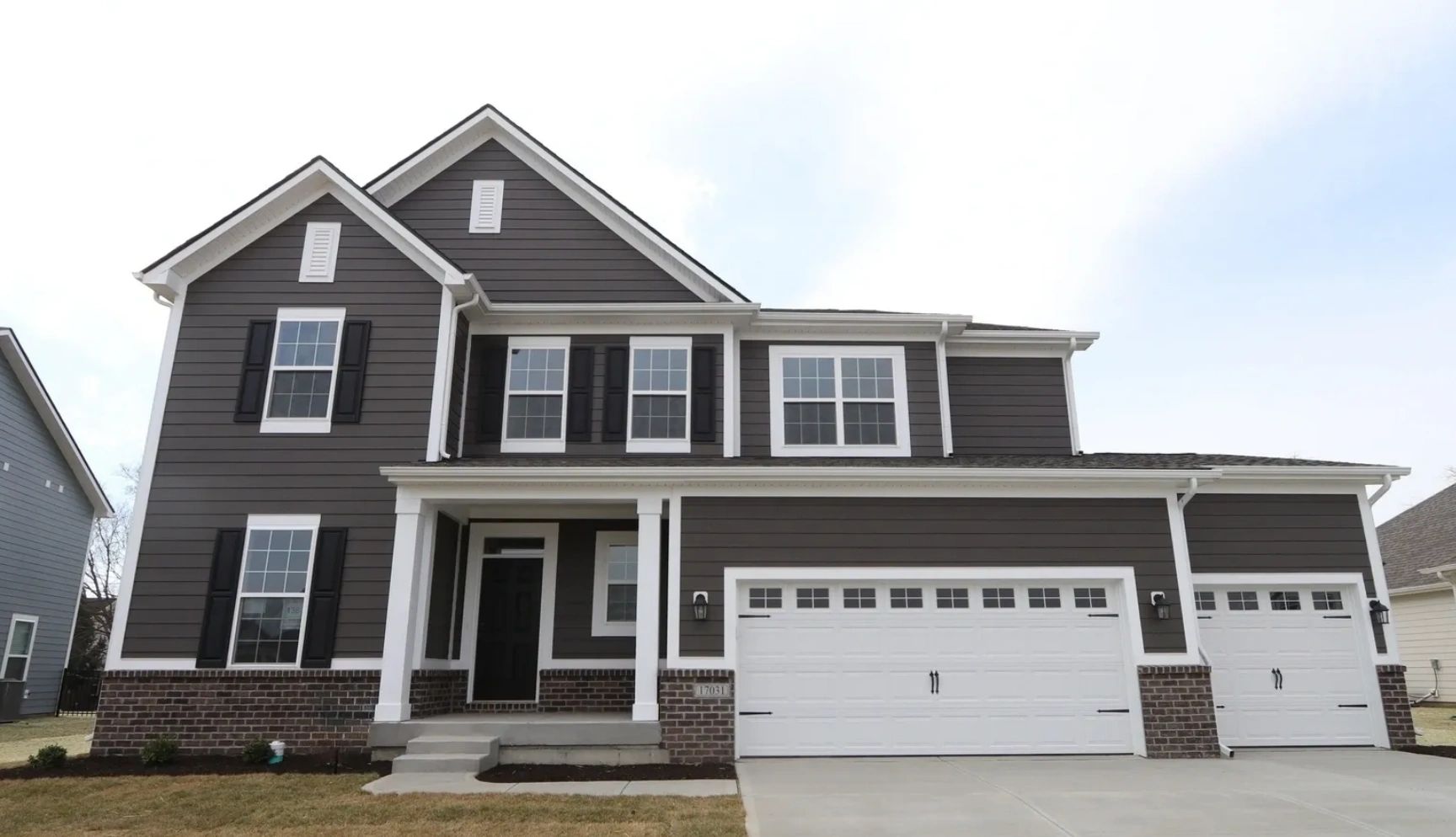 Two-story modern house with dark siding and white trim.