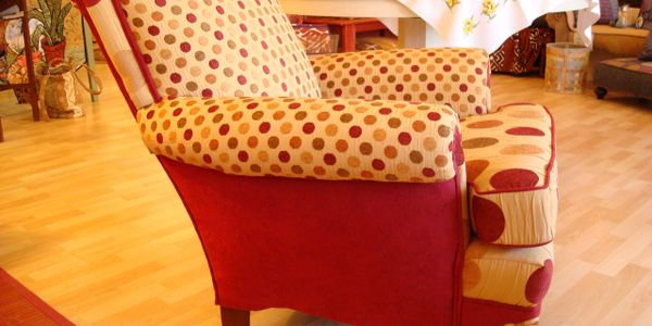 Polka dot patterned armchair in a cozy room with wooden flooring.