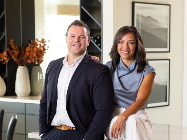 Smiling man and woman posing confidently indoors.