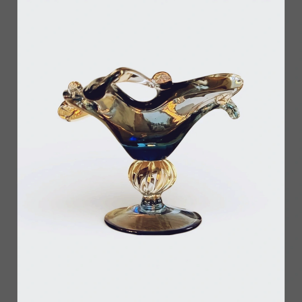 Elegant glass decorative bowl with a unique shape on a pedestal base.