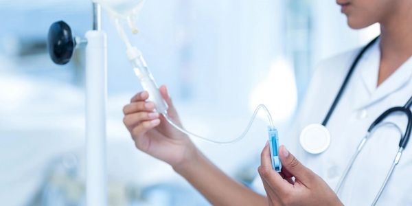 Medical professional preparing IV drip.