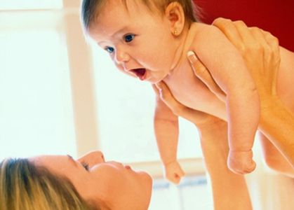 A mother lifting her baby overhead. 