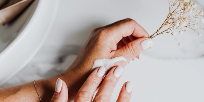 A hand rubbing a cream on his hand