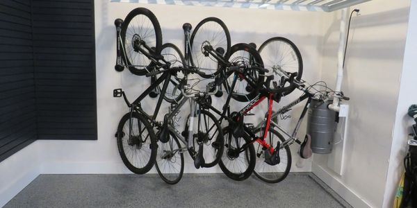 Five adult bicycles storage & slatwall panels underneath ceiling mounted 4' x 8' storage platform