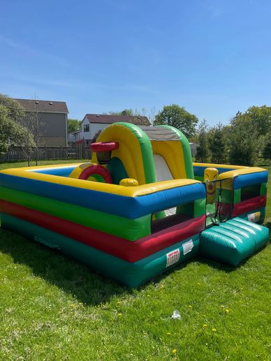 Colorful inflatable bounce house set up on a sunny lawn.