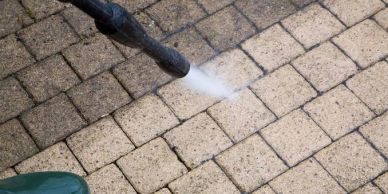 Pressure washing a tiled floor.