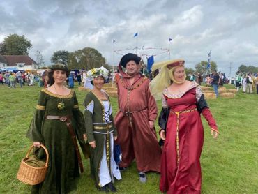 Four people in medieval costumes at an outdoor event.