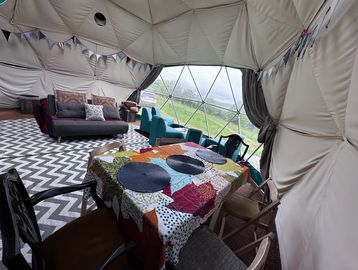 Cozy glamping dome with vibrant decor and outdoor views.