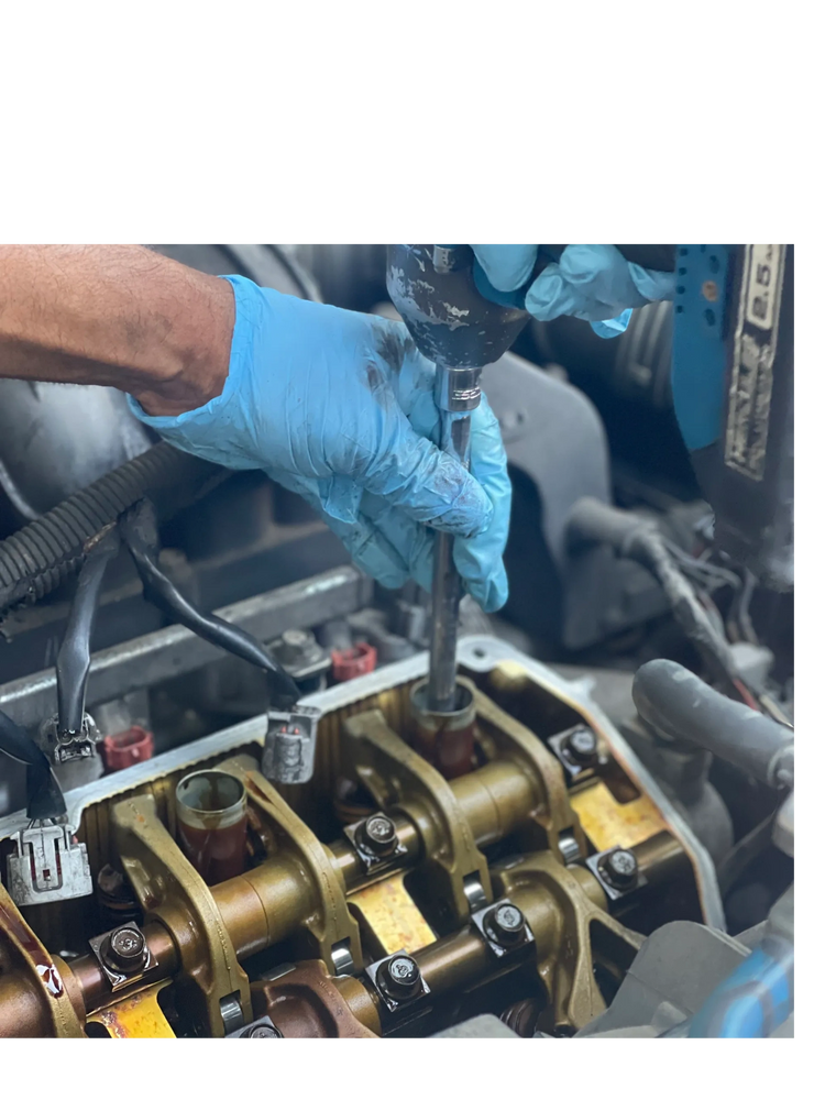 Mechanic wearing using a tool on a car engine component. 
engine repair, 