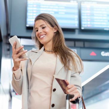Smiling Woman at an airport checking her cellphone